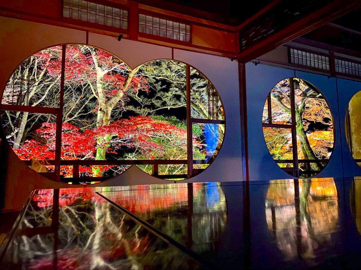Round temple windows framing autumn maples